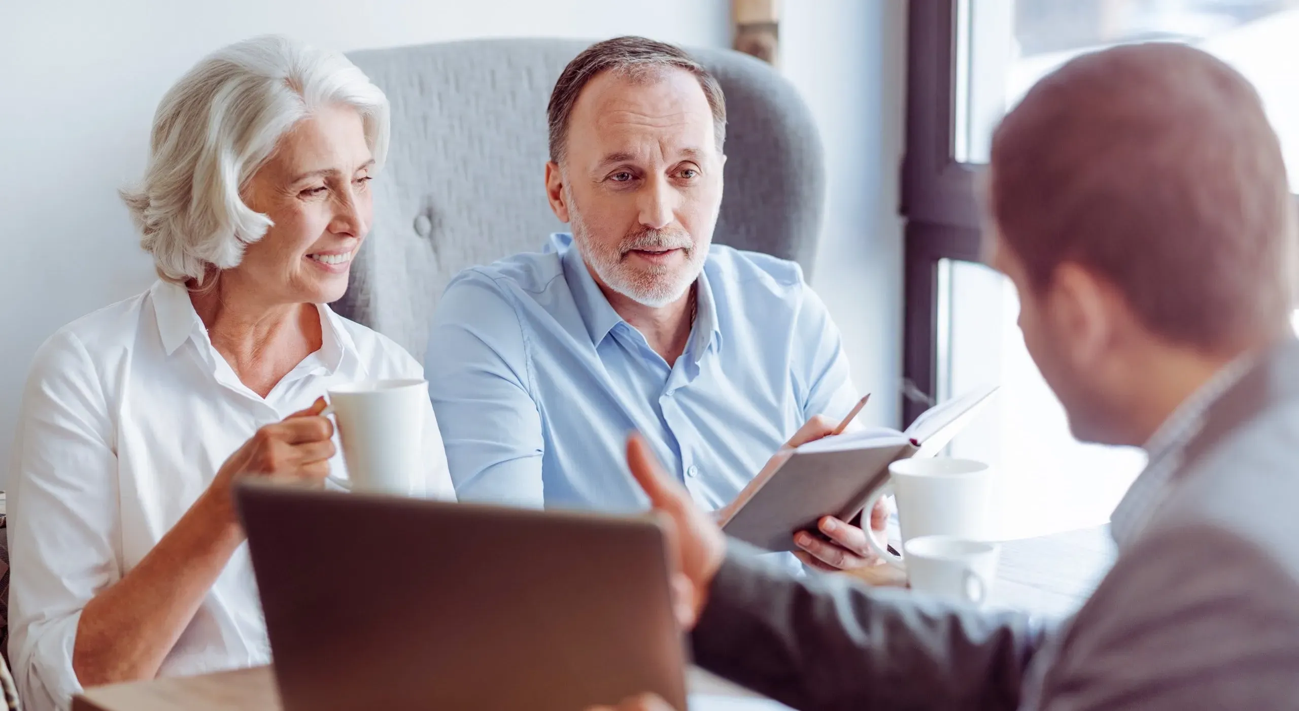 Couple de seniors en rendez-vous pour un contrat de prévoyance obsèques.